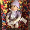 A purple M&M baby doll from Ashton Drake.