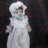 Identifying a Porcelain Doll - doll wearing an eyelet trimmed bonnet and pinafore over a pink dress
