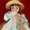 Identifying a Porcelain Doll - doll with a hanky to her nose, wearing a straw hat and blue satin dress with eyelet bodice and skirt, holding a stuffed bunny