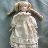 Identifying a Porcelain Doll - small doll wearing a light peach colored dress