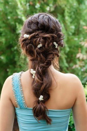 A brunette bridesmaid with a decorative hairstyle.