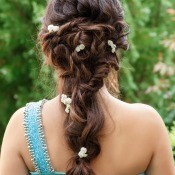 A brunette bridesmaid with a decorative hairstyle.