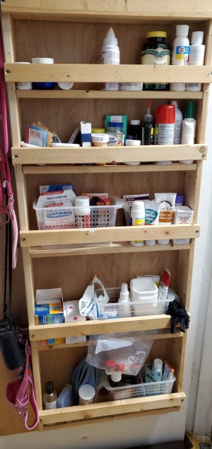 A shelf unit built on the back of a bathroom door.