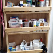 A shelf unit built on the back of a bathroom door.