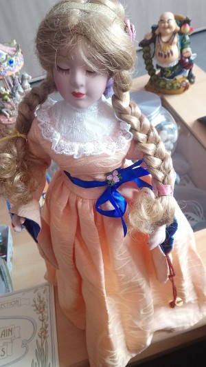 Value of a Porcelain Doll - doll in peach colored dress with blond braids