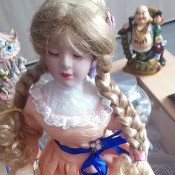 Value of a Porcelain Doll - doll in peach colored dress with blond braids