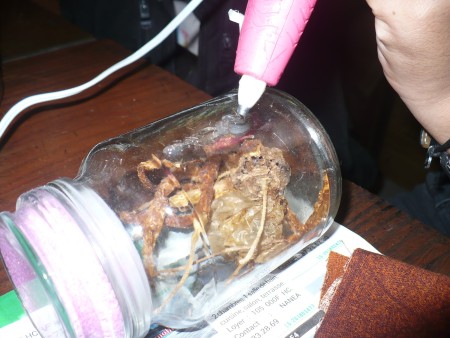 Decorative Fabric Covered Glass Canisters - making a line of hot glue from the top to the bottom side of the jar