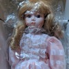 Value of a Seymour Mann Doll - doll wearing a pink dress with white lace and ribbon on bodice and sleeves, wrapped in plastic