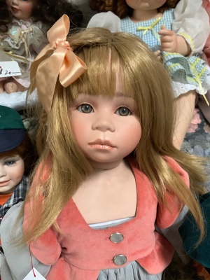 Identifying a Porcelain Doll - doll with peach colored bow in her hair
