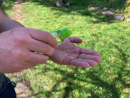 A man applying hand sanitizer to his bare hands.