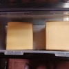 Sliced cheese in a plastic container.