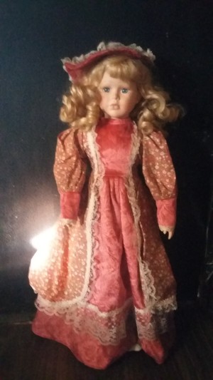 Value of a Porcelain Doll - doll in salmon colored dress and hat