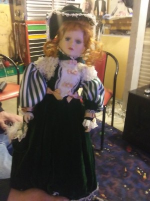 Value of a Porcelain Doll  - doll wearing a period dress, long skirt, striped puffy sleeves, and a lacy bodice