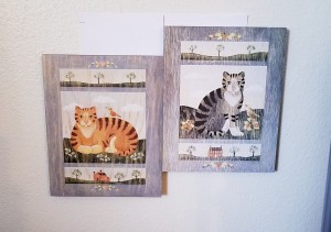 Two cat pictures in frames.