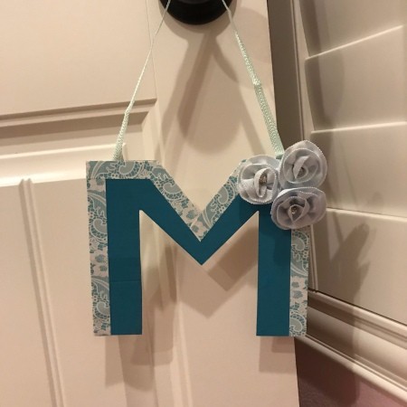 Hanging Initial Letter Decor - letter with flowers on one top corner hanging from a door handle