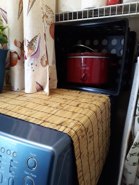 storage crates behind a washer and dryer for storage.