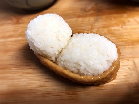 Making Animal Shaped Sushi - the cat's head is a smaller ball resting on the edge of the bed