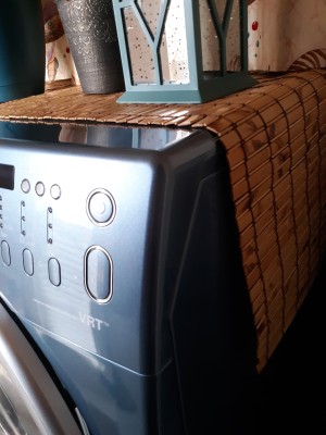 A table runner on top of a washer and dryer.