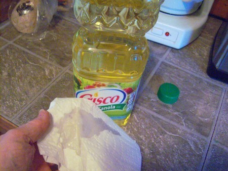 Removing Sticky Adhesive Residue from Plastic - paper towel with oil on it
