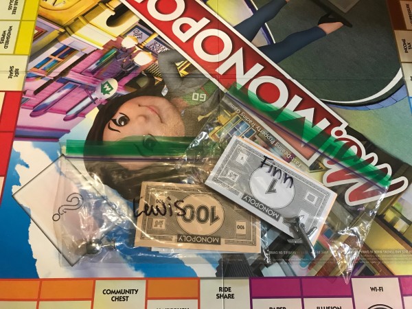 A Monopoly board game with the pieces saved in sandwich bags.