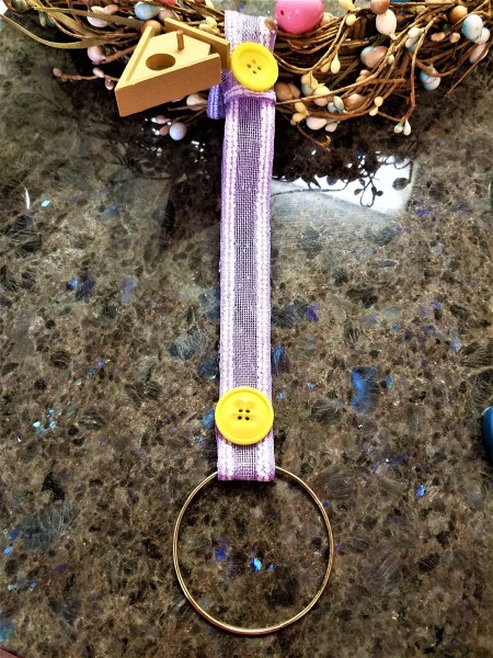 Repurposed Easter Wreath - metal ring with ribbon hanger, two yellow buttons- one at each end, and the birdhouse in place