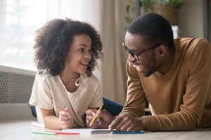 A girl and her dad doing school work.