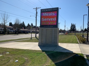 Picking Up Free School Lunch During COVID-19 Closures - school sign with times for meals