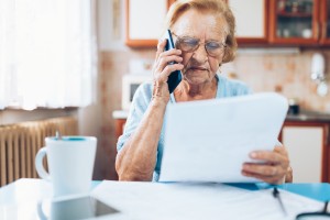 An older woman calling for help on a bill.