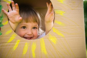 A child looking through a sun in a cardboard box.