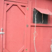 A chicken coop with a closed door.