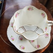 A tea cup with a mustache tray inside the cup.