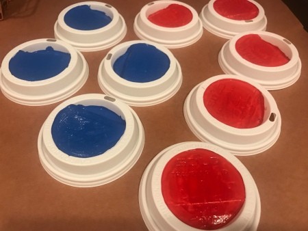 Outdoor Tic Tac Toe Game - four blue and five red painted lids