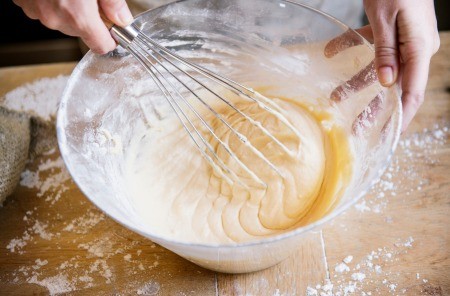 Cake batter being whisked in a bowl.