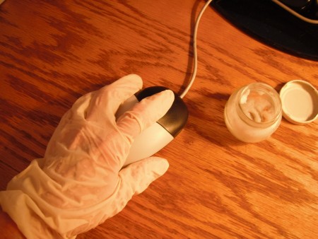 A gloved hand using a computer mouse.