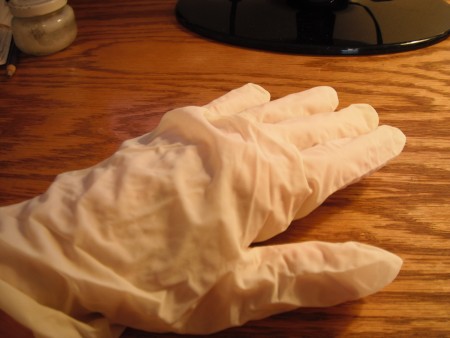 A gloved hand to moisturize with coconut oil.