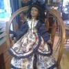 Value of a Collector's Choice Doll by Dandee - doll wearing a floral tiered dress, standing on a chair