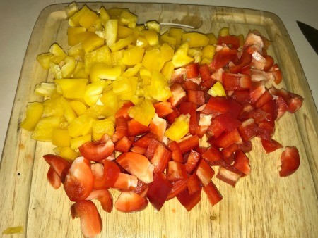 Chopped peppers on a wooden cutting board.