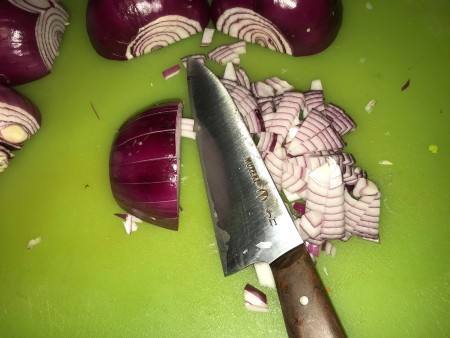 A red onion being chopped.