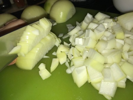 A white onion being chopped.