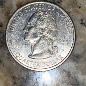 A U.S. quarter on a marble countertop.