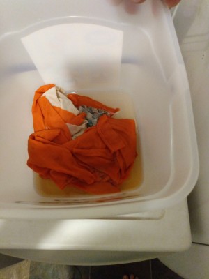 A container of fabric rags in a sanitizing solution.