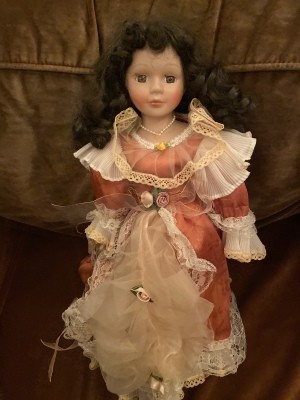 Identifying a Porcelain Doll - doll wearing a dark pink satin dress with white lace trim