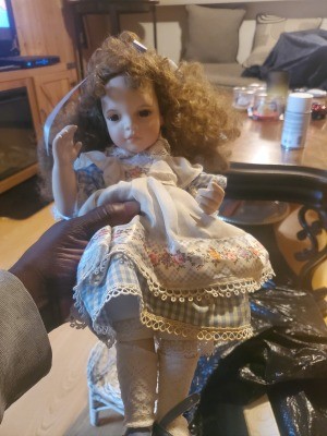 Value of an Ashton Drake Doll - doll wearing a blue and white gingham dress with a white apron with flowers along the lower edge