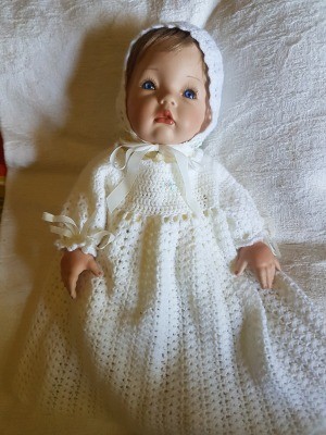 Identifying a Porcelain Doll - baby doll wearing a long white christening style dress and cap