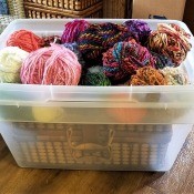 Two Lidless Tubs Become One - one tub inside the other making two storage bins, top filled with yarn balls