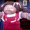 Selling a Cabbage Patch Doll - brown skinned girl Cabbage Patch doll wearing red overalls and a white shirt