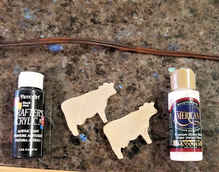 Spring Calving Season Cowboy/Cowgirl Wreath - two bottles of paint, extension cord, and two cow cutouts