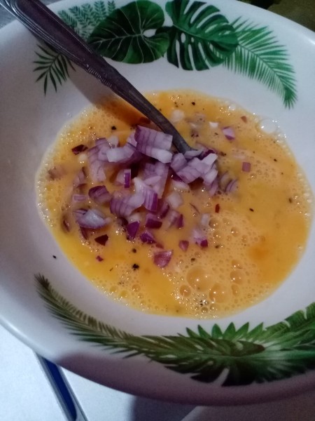 adding onion to egg