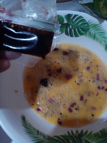 adding soy sauce to egg