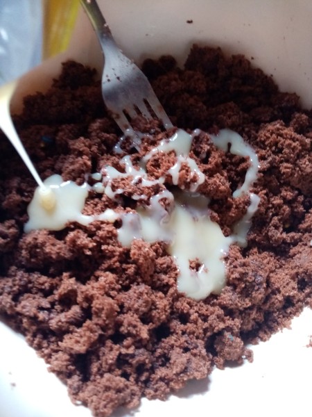 adding icing to cake crumbs